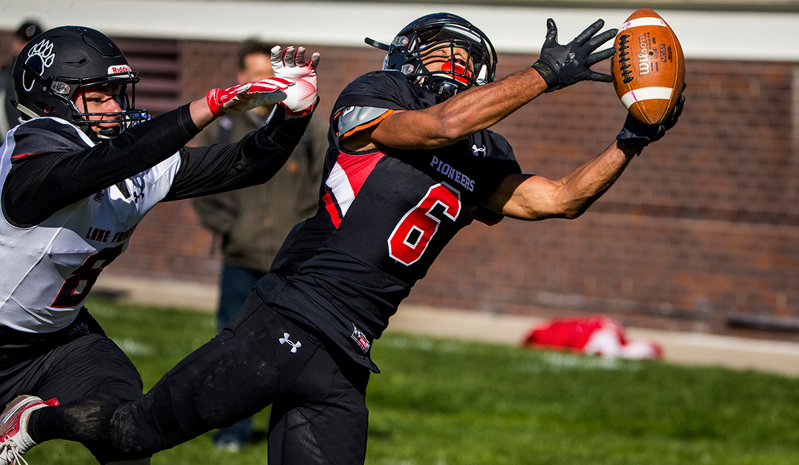Max Hill '20 makes a diving catch playing for the Grinnell Pioneer football team.