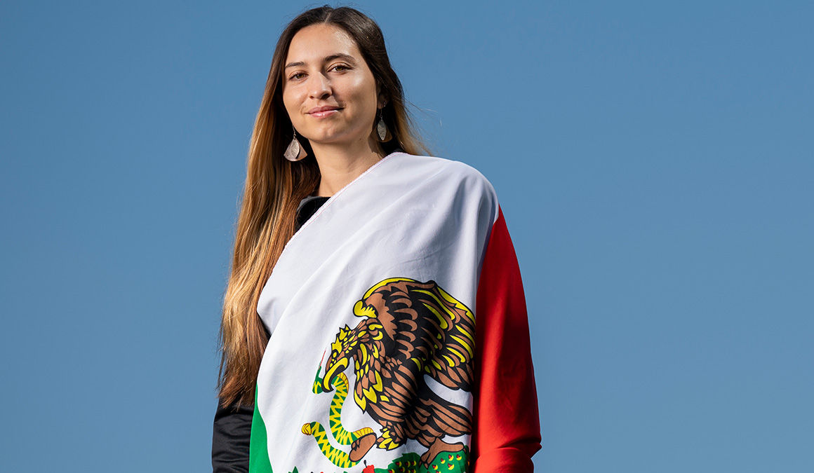 Valencia Alvarez ’20 poses draped in the Mexican flag.