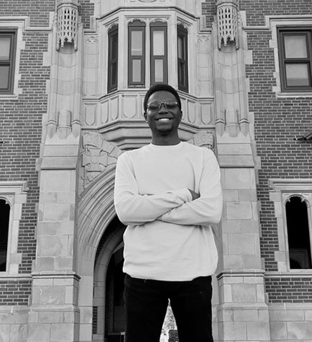 Rexford Essilfie ’22 stands in front of Gates Tower on the campus of Grinnell College.